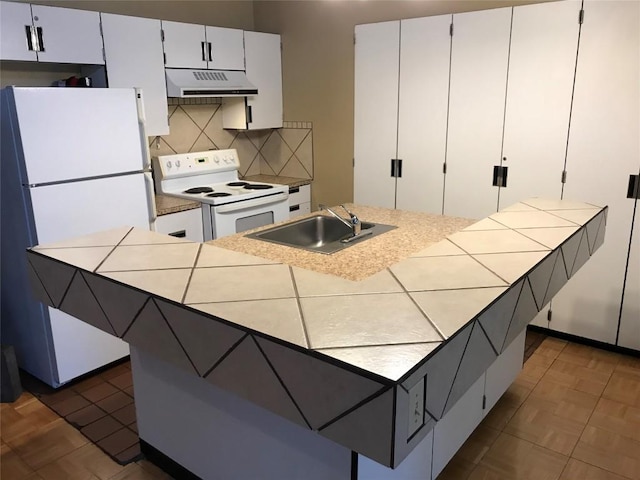 kitchen with sink, an island with sink, white cabinets, white appliances, and backsplash