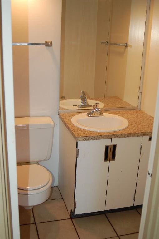 bathroom featuring vanity, tile patterned floors, and toilet