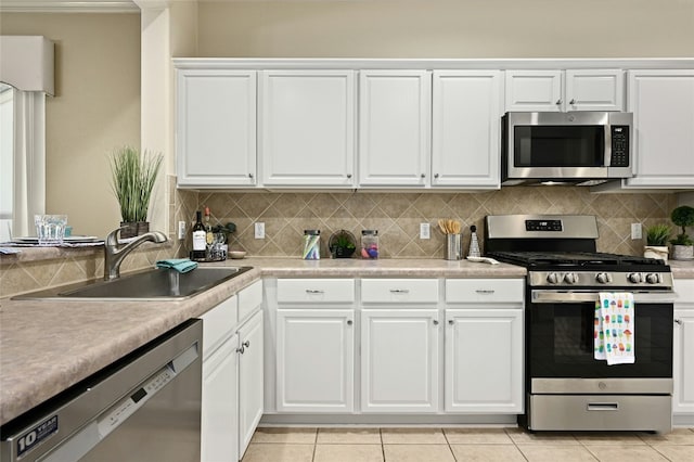 kitchen with stainless steel appliances, sink, white cabinets, and backsplash