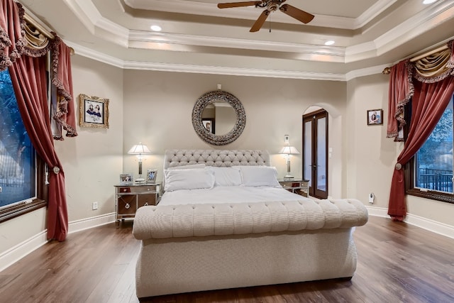 bedroom featuring ornamental molding, dark hardwood / wood-style flooring, and a raised ceiling