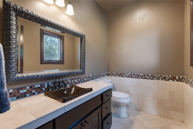 303 Camino Arbolago St, Lakeway, TX 78734 - bathroom with vanity, tile walls, tile patterned flooring, and wainscoting