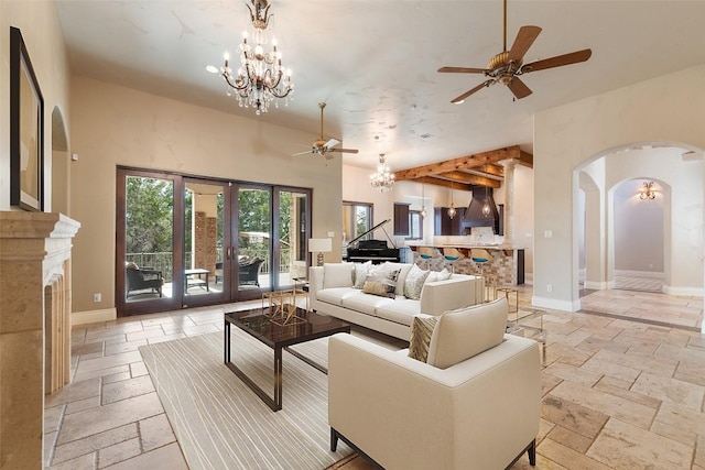 303 Camino Arbolago St, Lakeway, TX 78734 - living room featuring stone tile flooring, ceiling fan, arched walkways, and a chandelier