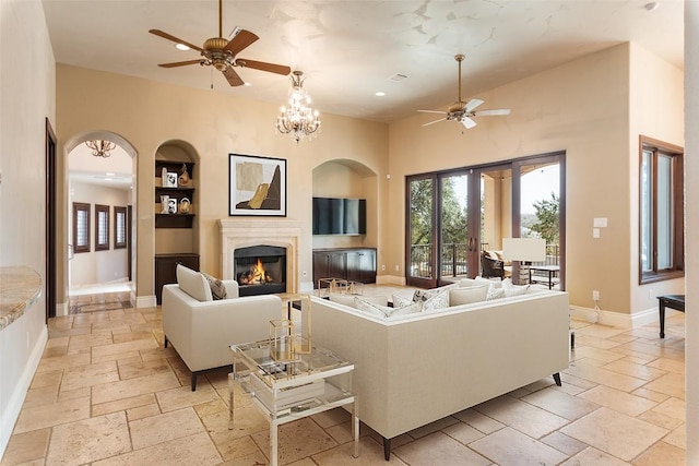 303 Camino Arbolago St, Lakeway, TX 78734 - living room with ceiling fan, stone tile floors, built in features, recessed lighting, and a high end fireplace