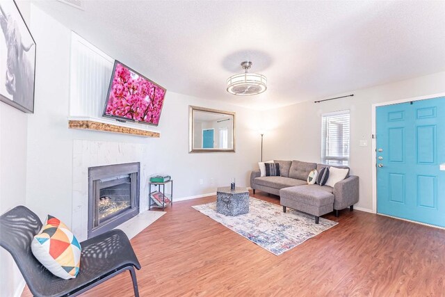 living room with hardwood / wood-style flooring, a textured ceiling, and a fireplace