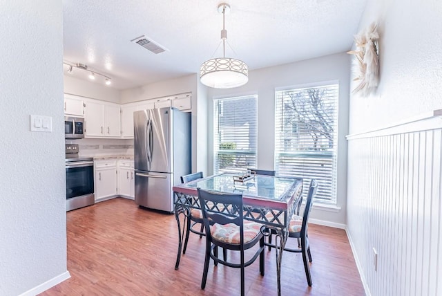 dining room with hardwood / wood-style flooring and a textured ceiling