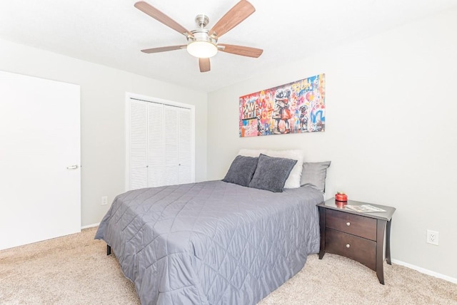 bedroom featuring light colored carpet, a closet, and ceiling fan