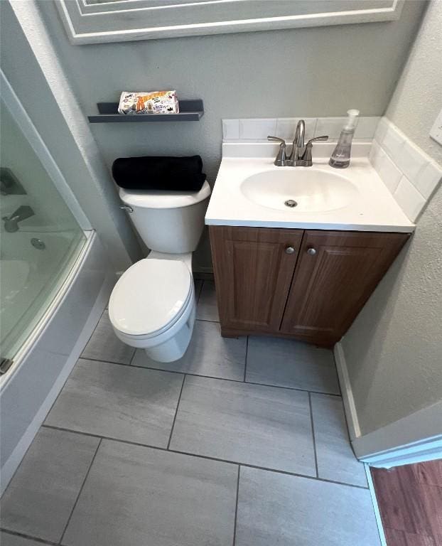 full bathroom with enclosed tub / shower combo, vanity, and toilet