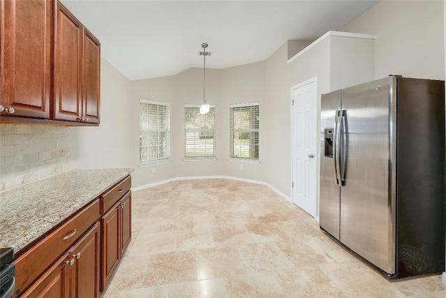 kitchen with stainless steel refrigerator with ice dispenser, light stone counters, decorative light fixtures, vaulted ceiling, and backsplash