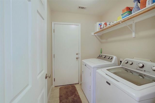 laundry area with light tile patterned floors and washing machine and clothes dryer