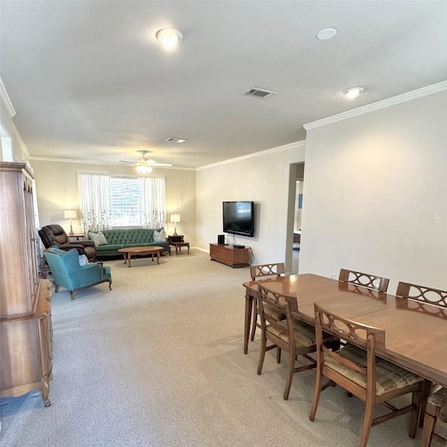 dining room with crown molding, carpet floors, and ceiling fan