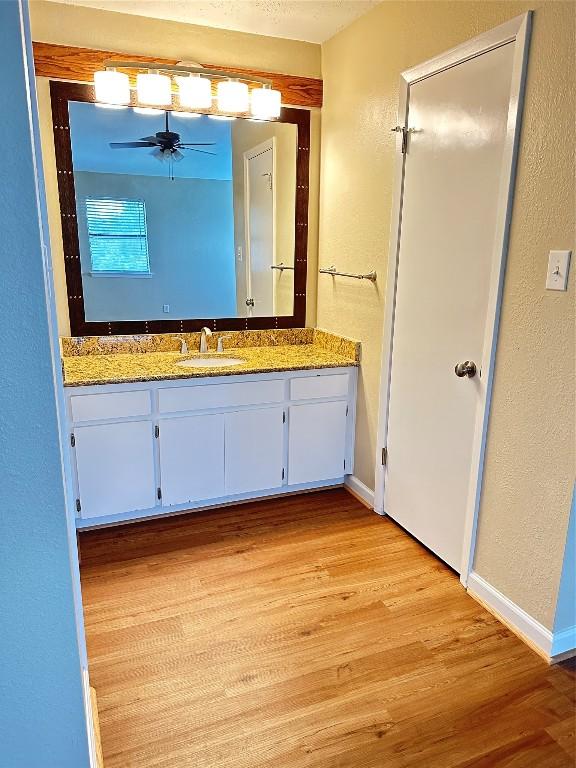 bathroom with ceiling fan, vanity, and hardwood / wood-style floors