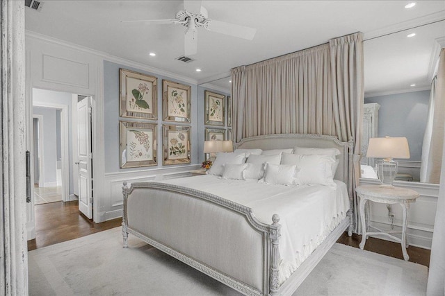 bedroom with crown molding, recessed lighting, visible vents, and a decorative wall