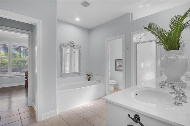 full bathroom with a sink, tile patterned flooring, toilet, visible vents, and a garden tub