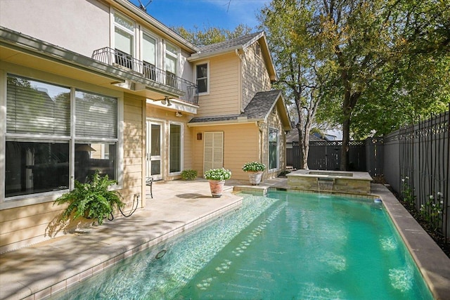 back of house with a fenced in pool, a fenced backyard, a balcony, and a patio