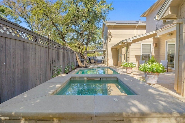 view of pool with a patio, an in ground hot tub, a fenced in pool, and a fenced backyard