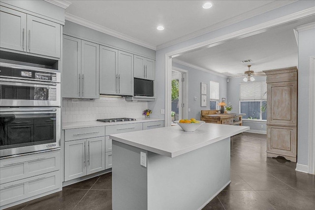 kitchen with decorative backsplash, stainless steel double oven, dark tile patterned flooring, light countertops, and recessed lighting