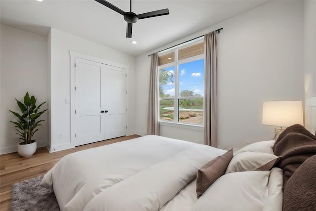 bedroom with recessed lighting, a closet, light wood-style floors, ceiling fan, and baseboards