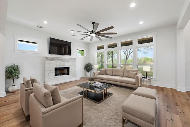 living room featuring light wood-style floors, a fireplace, and recessed lighting