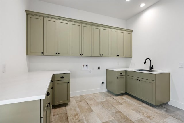 laundry area featuring cabinet space, baseboards, electric dryer hookup, washer hookup, and a sink