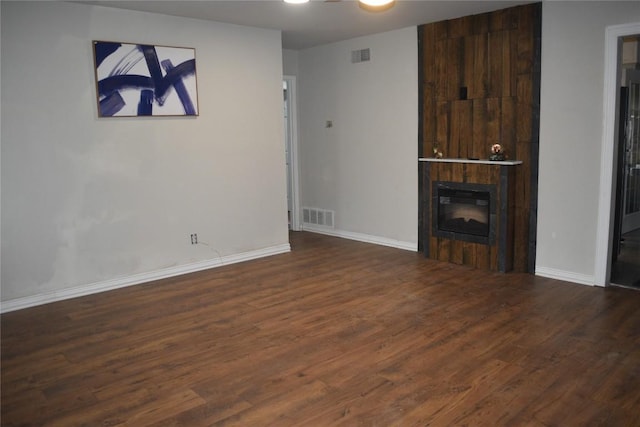 unfurnished living room with a fireplace and dark hardwood / wood-style flooring