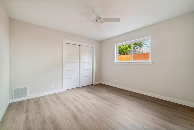 unfurnished bedroom featuring light hardwood / wood-style floors, a closet, and ceiling fan