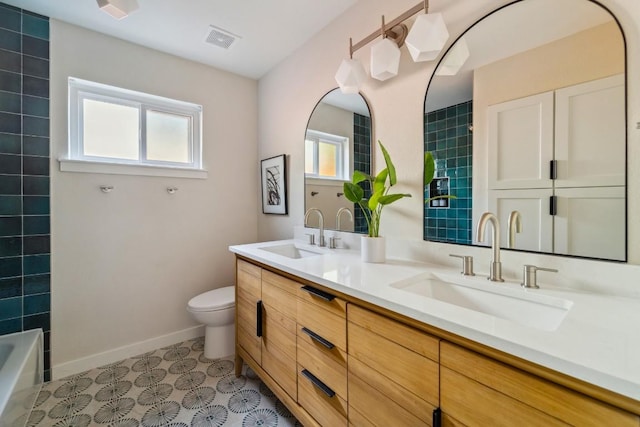 bathroom featuring vanity, tile patterned flooring, toilet, and a healthy amount of sunlight