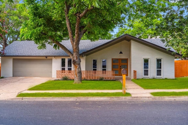 ranch-style home featuring a garage and a front lawn