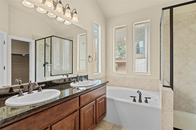 bathroom featuring tile patterned flooring, vanity, independent shower and bath, and vaulted ceiling