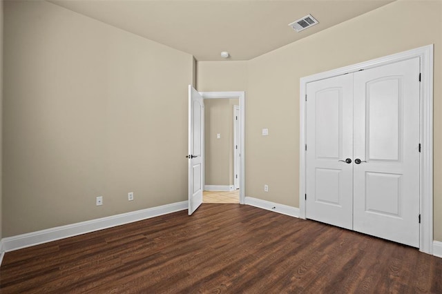 unfurnished bedroom featuring a closet and dark hardwood / wood-style floors