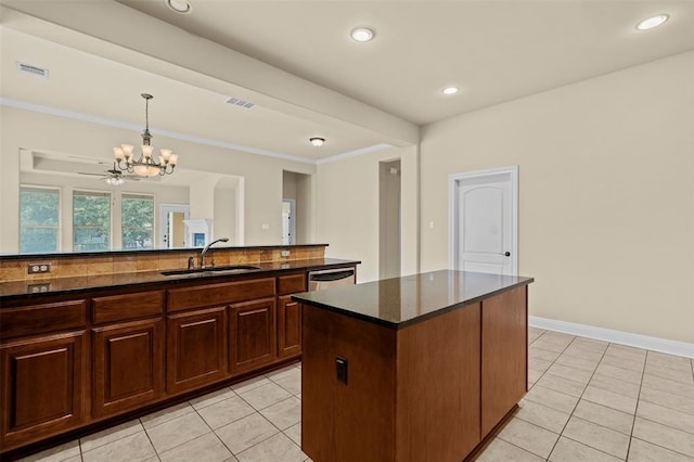 kitchen with sink, tasteful backsplash, decorative light fixtures, a center island, and light tile patterned floors