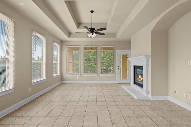 interior space with a raised ceiling and ceiling fan