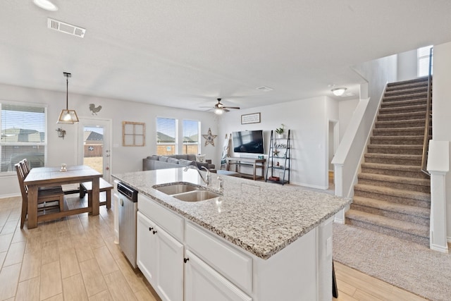 kitchen with sink, white cabinetry, dishwasher, an island with sink, and pendant lighting