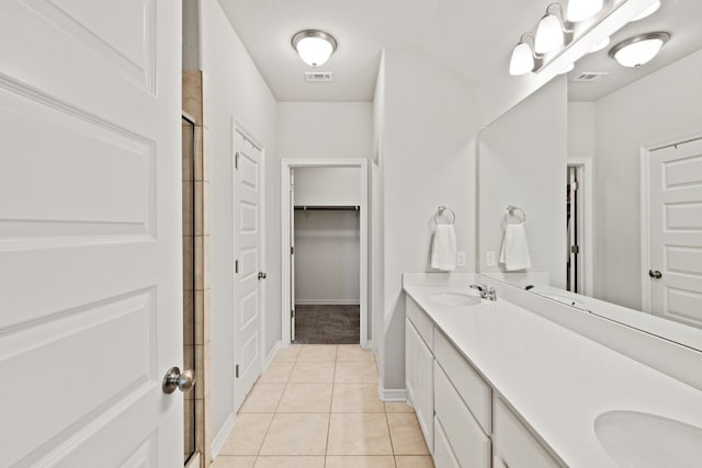 bathroom featuring tile patterned floors, a shower with shower door, and vanity