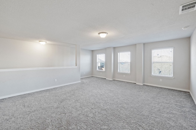 empty room featuring carpet and a textured ceiling