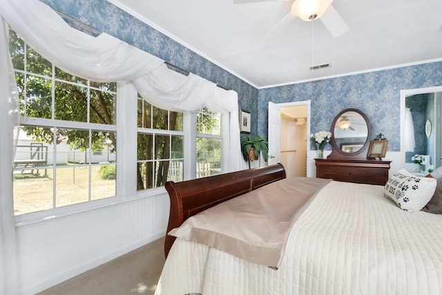 carpeted bedroom featuring ornamental molding, a spacious closet, and ceiling fan