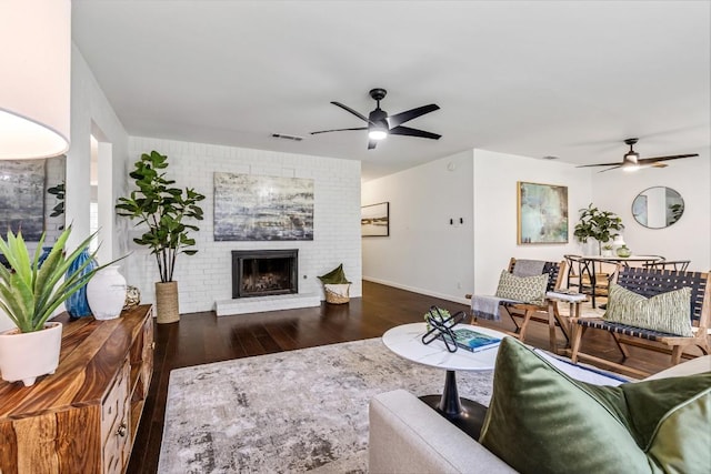 living room with ceiling fan, dark hardwood / wood-style floors, and a fireplace