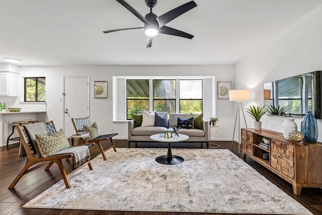 living room featuring ceiling fan and dark hardwood / wood-style floors