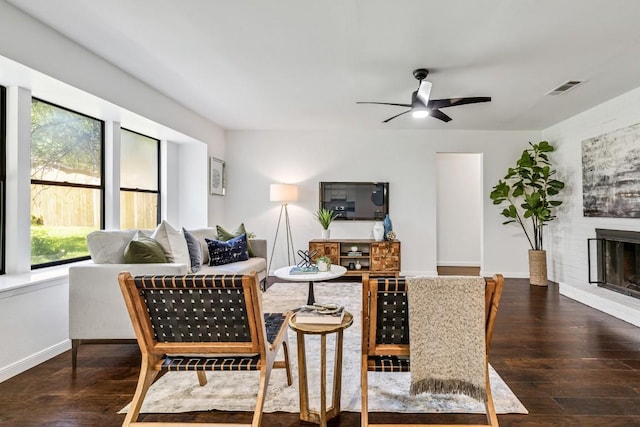 living room with ceiling fan, a fireplace, and dark hardwood / wood-style flooring