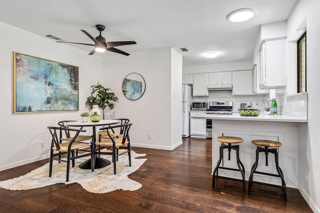 dining area with dark hardwood / wood-style flooring, sink, and ceiling fan