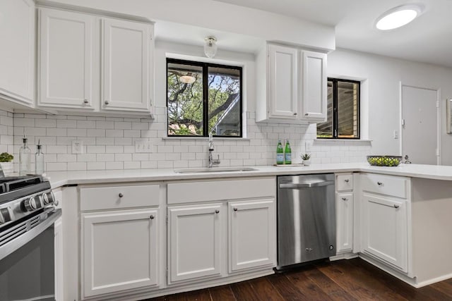 kitchen with sink, tasteful backsplash, appliances with stainless steel finishes, dark hardwood / wood-style floors, and white cabinets