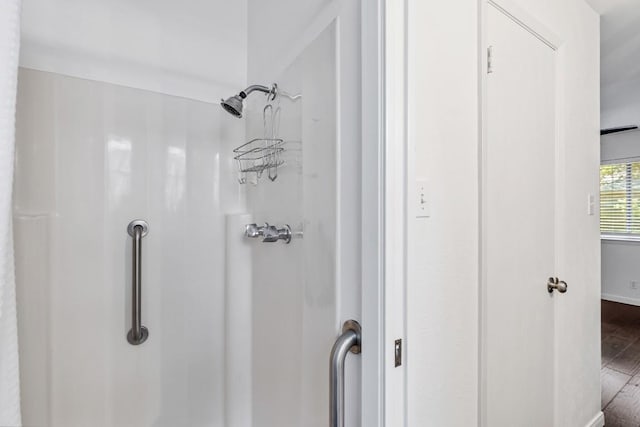 bathroom with hardwood / wood-style floors and a shower