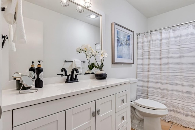 bathroom featuring vanity, tile patterned flooring, and toilet