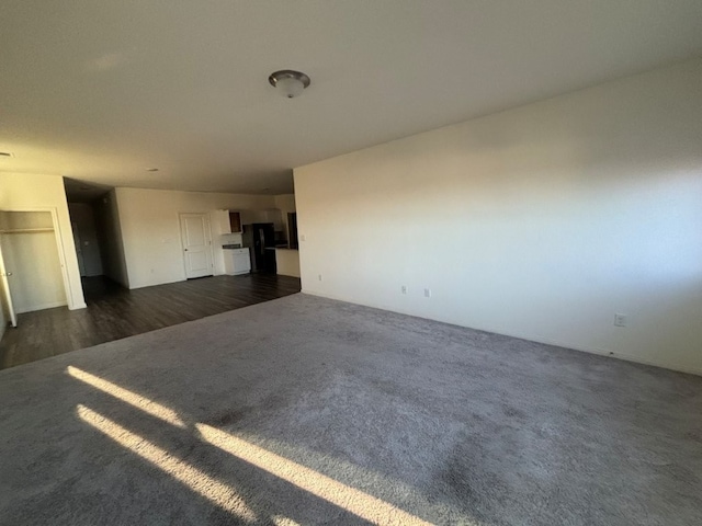 unfurnished living room featuring dark colored carpet