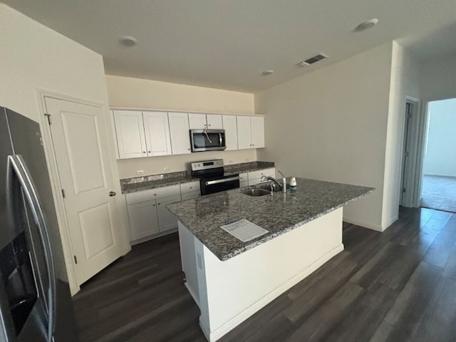 kitchen with appliances with stainless steel finishes, white cabinetry, sink, a kitchen island with sink, and dark wood-type flooring