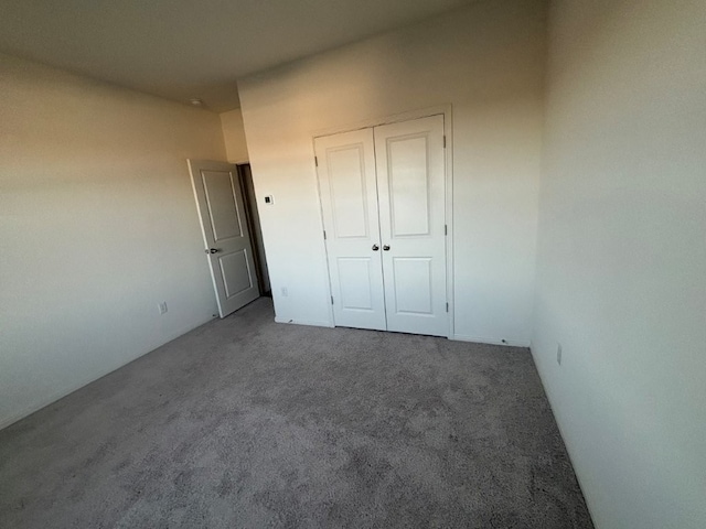 unfurnished bedroom featuring carpet floors and a closet