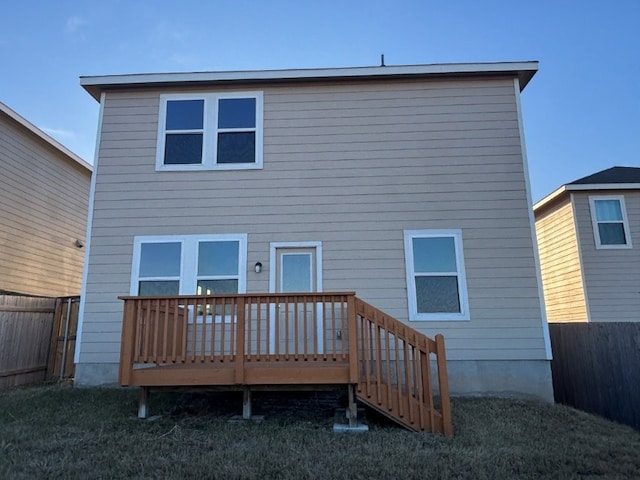 back of house with a wooden deck and a lawn