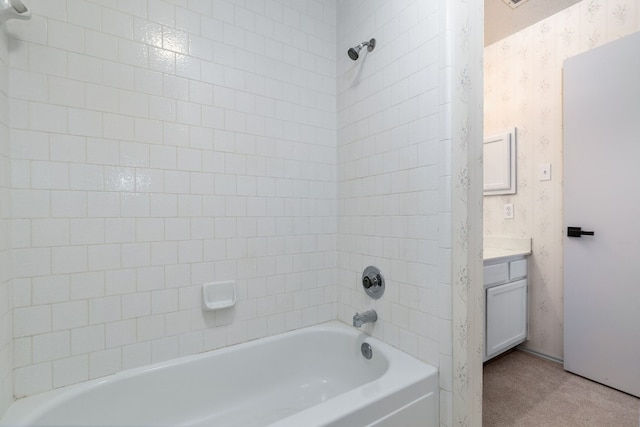 bathroom with tiled shower / bath and vanity