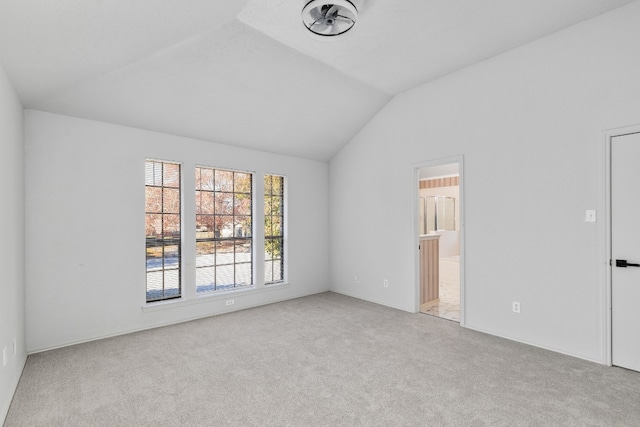 carpeted empty room featuring lofted ceiling