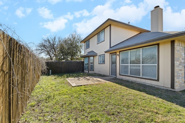 rear view of house with a patio and a lawn