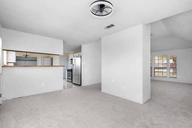 unfurnished living room featuring vaulted ceiling and light carpet